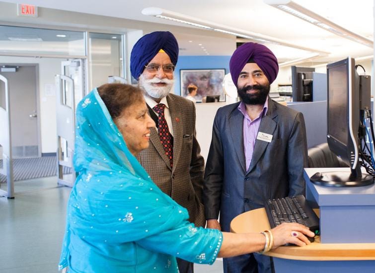 FVRL staff member helping Punjabi couple at library